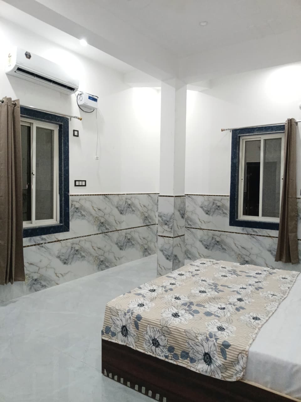 Deluxe AC room with a wall-mounted air conditioner, two windows and curtains